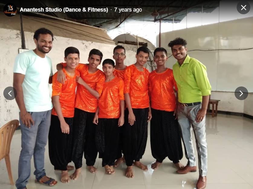 Boys' batch in orange costumes with instructors